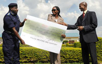 CGP Emmanuel Gasana hands the dummy check to Minister Agnes Karibata. Looking on is Minister Fazil Harerimana. (Photo T Kisambira)