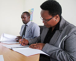 (R-L) Claire. M. Uzamukunda the Vice president of Radio Ishingiro signs her License with Patrice Mulama, the Executive Secretary of the Media High Council (Photo: T.Kisambira)