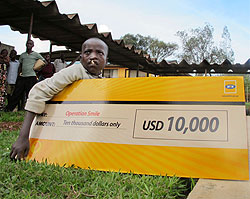 Alex Buhungiro, from Kirehe Distric,t holding a dummy cheque donanted to Operation Smile by MTN. (Photo T Kisambira)