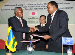 Minister Gatsinzi (L) exchanges the agreement ith IOM's Ashraf El Nour as Japanese Ambassador to Rwanda Kunio Hatanaka looks on. (Photo J Mbanda)