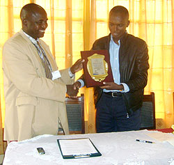 Director General Yves Muyange presents the award to Branch manager Emanuel Kalimunda (Photo S. Nkurunziza)