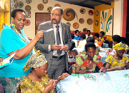 Joy Ndungutse (L),Gahaya Links founder, explains to UNAIDS Executive Director, Michel Sidibu00e9, the activities that women engage in (Photo. G. Mugoya)