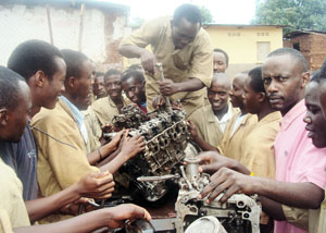 Students of CFR Kibungo helped by an instructor to assemble a motor engine. (Photo: S. Rwembeho)