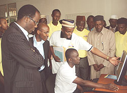 Kigali City Mayor, Fidele Ndayisaba (L) Ignace Gatera and Sheikh Swaleh Habimana being shown the web applications ( Photo G. Mugoya.)