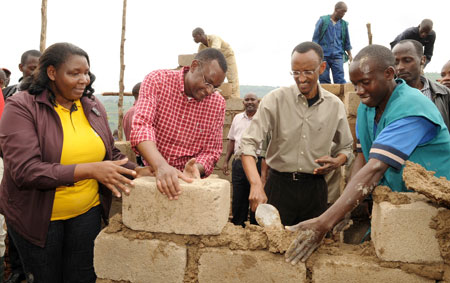 President Kagame and the Speaker of the EALA, Abdi Haithar Abdirahin (in red chequered shirt), Helping build a House for the disadvantaged during Umuganda yesterday. Left is the Mayor of Nyarugenge, Solange Mukasonga (Photo Urugwiro Village)