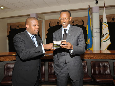 President Kagame admiring the 'Unity is Strength Diversity Awardu2019, as  the foundation's Executive Director, Sergio Belfor, gives some explanation. (Photo; Urugwiro Village).