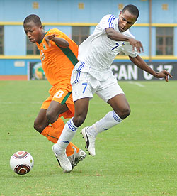 Charles Tibingana (R) fights for the ball with an Ivory Coast player during the 2011 Africa Junior Championship. (File photo)