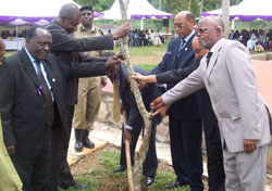  Mugambage (second left) is joined by PS James Mugume (with hoe) and other officials in planting a landmark tree at Lambu Memorial (Photo G Muramira)