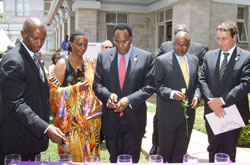 Kenyau2019s acting Foreign Minister Prof George Saitoti (c) lights a candle of hope. High Commissioner William Kayonga is extreme left (Courtsey Photo)