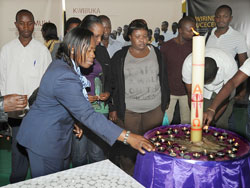 Minister Nsanzabaganwa (lighting candle), leads employees from her Ministry in a tour of the Genocide exhibition at Petit Stadium on Friday. (Photo J Mbanda).