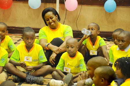 First Lady  Jeannette Kagame shares a light moment with children at Serena Hotel during a function to mark the Reading Day (Photo T.Kisambira).