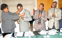 Kigali City Mayor Fidel Ndayisaba receives the patronage chain from Kampala Deputy Mayor Florence Namayanja (L). Looking on is PS Ministry of Local Government Cyrille Turatsinze and his Ugandan counterpart John Kashaka (Photo J Mbanda)