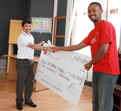 FINA Bank Managing Director, Rao G.Balivad,  handing over the dummy cheque to Kigali Gisozi Memorial Centre's Yves Kamurongi (Photo T.Kisambira).