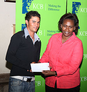 Kenya's  Ambassador to Rwanda, Rose Makena awards Grek Snow, the winner of the Pro KCB Golf Open, which ended yesterday.(Photo T. Kisambira)