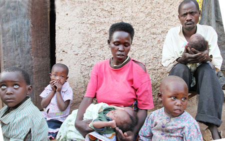 Murindabyuma (R) holding one of the triplets, his wife Nyirahabimana with the two and the rest of  his family (photo T.Kisambira)