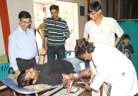 Members of the Indian Community chat with their colleague as he donates blood at UTEXRWA yesterday. The New Times / John Mbanda.