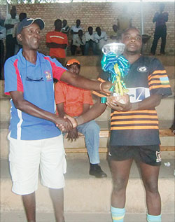 Buffaloes' Vincent Kamali (R) receiving the first ever UNR Grizzlies 7s trophy last weekend. Yesterday Buffaloes won the Inyange national rugby league. The New Times / File photo