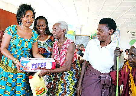  Julie Mutoni, the country manager of DHL Rwanda (L), giving food stuffs to the widows. The Sunday Times /Timothy Kisambira