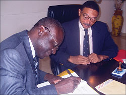 The chairman of Kenya Insitute of Bankers, John Waka, signing the MoU while SFB's Rector, Professor Reid Whitlock, looks on. The Sunday Times / Dias Nyesiga.