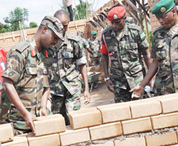 Chief of Defence Staff, Lt.Gen. Charles Kayonga (L) contributes to the renovation exercise at Kami Military Barracks, yesterday. The New Times / Courtesy.