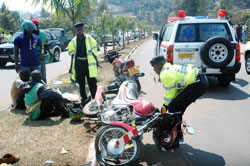 A traffic Police officer picks up a motorcycle after an accident. More accidents are likely in rainy weather.The New Times /File