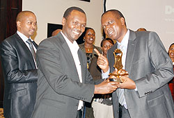 Ministry of Trade and Industry Permanent Secretary, Emmanuel Hategeka (L), receiving an award from the ICPAR President, Peter Rutaremara. The Sunday Times / File.