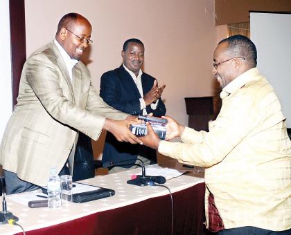 Local Government Minister James Musoni (L) hands over GPS equipment to Gasabo vice mayor (economic affairs), Jean Claude Munara, yesterday. Districts have received new kit to help accelerate the Imidugudu programme. The Sunday Times / J. Mbanda. 