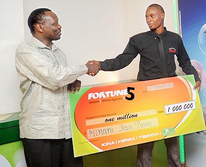 Robert Bayigamba (L) Chairman of Rwanda Gaming Association, congratulates Jean Pierre Minani who won a Rwf1m jackpot. The New Times / J.  Mbanda.