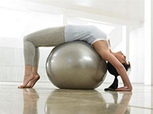 A woman working out with a pilates ball