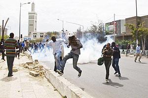 People flee as riot police fire tear gas to disperse anti-government protestors, in Dakar, Senegal Wednesday,  Feb. 15, 2012. Net photo