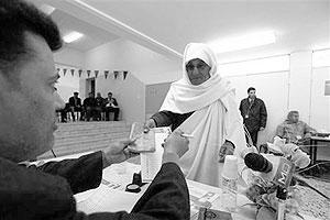 A woman receives her ballot paper at a polling station during the local council election in Misrata, February 20, 2012. Net photo