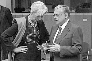 Managing Director of the International Monetary Fund Christine Lagarde (left) speaks with Greek Prime Minister Lucas Papademos during a round table meeting of eurozone Finance Ministers on Monday. Net photo