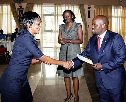 The Minister for Youth, Jean Philbert Nsengimana (R), hands a certificate to Jacky Ndayisenga, one of the graduands, yesterday.The New Times  / Timothy Kisambira