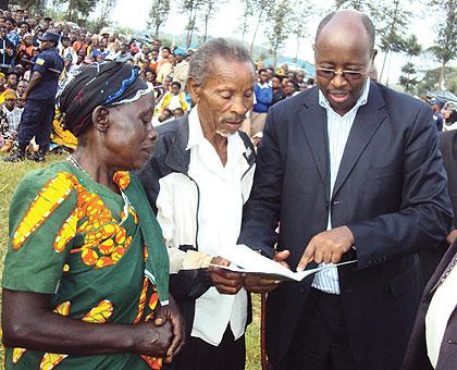 Local Government Minister, James  Musoni, explains to Huye residents  the details of the Family Performance Contract notebook. The New Times / J.P.  Bucyensenge..