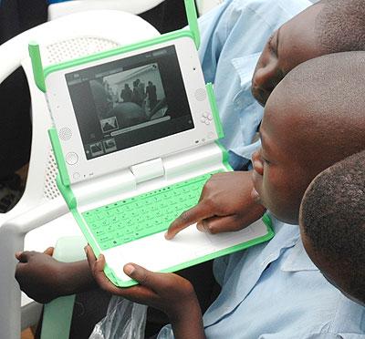 Kagugu Primary School boys try to take photographs with one of the Lap tops given to them. The New Times / File.