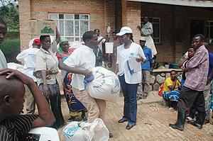 Returnees from Uganda getting food supplies upon their arrival last year. Some refugees are seeking Ugandan citizenship. The New Times / File.