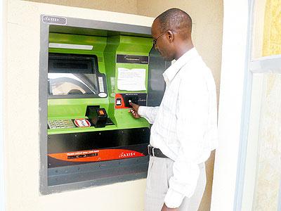 A customer withdraws money from an ATM machine. Banks give high interest rates to discourage withdrawals. The New Times/ File.