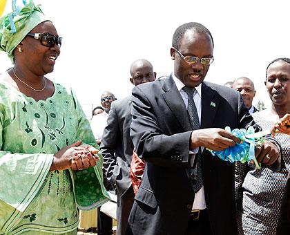 KCC Mayor, Fidele Ndayisaba (C), cuts the tape to officially launch the Agaseke Exhibition Week at Petit Stade.  The New Times / Timothy Kisambira.