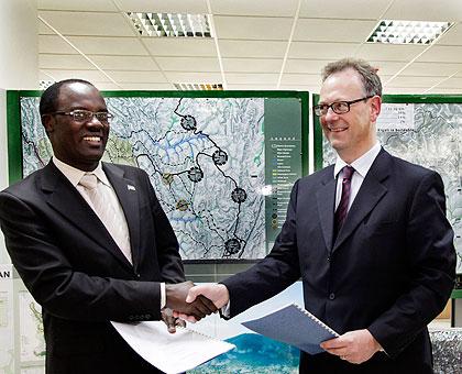 Mayor Fidele Ndayisaba (L) and Pierre Guislain, the Director of Investment Climate at World Bank, exchange documents after the signing yesterday.  The New Times / Timothy Kisambira.