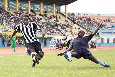 APR's Thailand-born St Preux Leonel tries his luck from a distance as Police's Jean Bosco Uwacu slides in during yesterday's league match played at Amahoro stadium. The New Times / T. Kisambira.