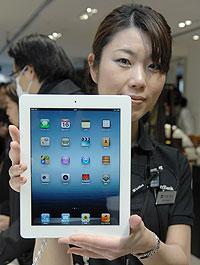 A staff member displays Apple's new iPad in Tokyo's Ginza shopping district, Japan, on March 16, 2012. Net photo.
