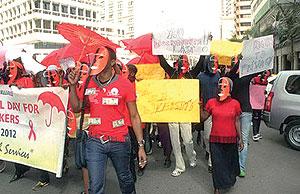 Masked sex workers recently march through the streets to demand access to government services, in Nairobi, Kenya. Net photo.