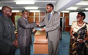 Abdirahim Abdi (R) shakes hands with Phillip Kiriro, EAFF president as other members look on. The New Times / Courtesy.