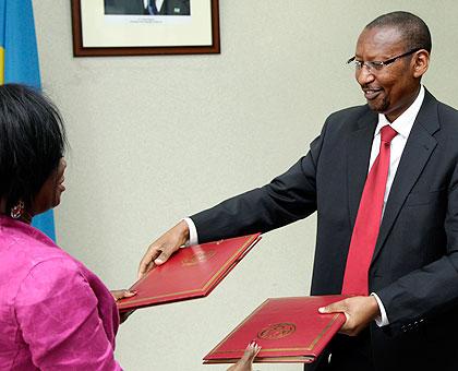 Mimi Ladipo, WB Country Manager (L) exchange documents with Finance Minister John Rwangombwa after the signing  yesterday. The New Times / Timothy Kisambira.