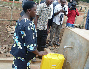 Antoinette Uwimana fetches water from the newly installed water tap.  The New Times / J.P. Bucyensenge.