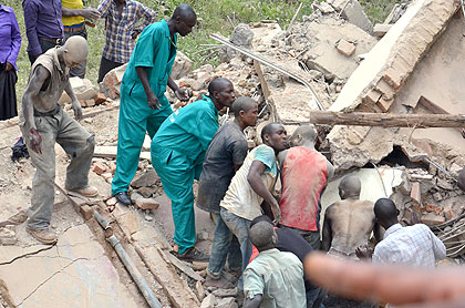 On lookers and survivors trying to save the lives of people who are trapped under the rubble of a Kigali building which caved in today, afternoon. The New Times/Courtesy photo.