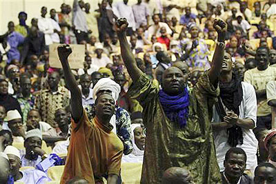 Malians, who originate from the north, pump their fists in the air during a meeting at the Palace of Congress in Bamako April 4, 2012.  Agencies.