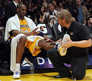Kobe Bryant receives help from a trainer during a timeout in the game against the Houston Rockets on Friday. Net photo.