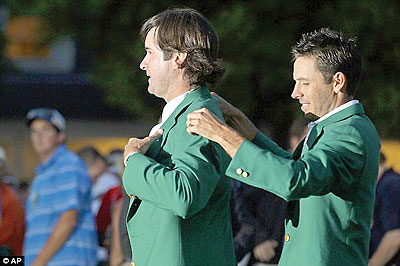 Prior champion Charl Schwartzel helps Watson put on the green jacket. Net photo.