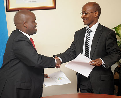 Ignace Gatare (R) hands over to Jean Philbert Nsengimana, yesterday. The New Times / John Mbanda.